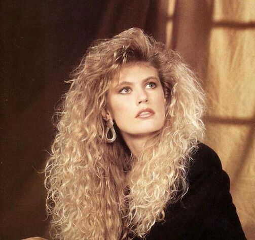 Woman in the 80s has a perm and poses for a photo